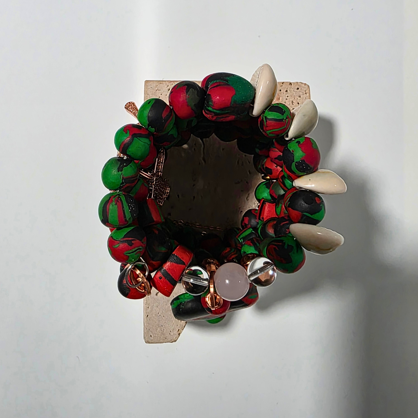 Pan-African clay bead bracelet with copper chains and crystal accents. Overhead shot