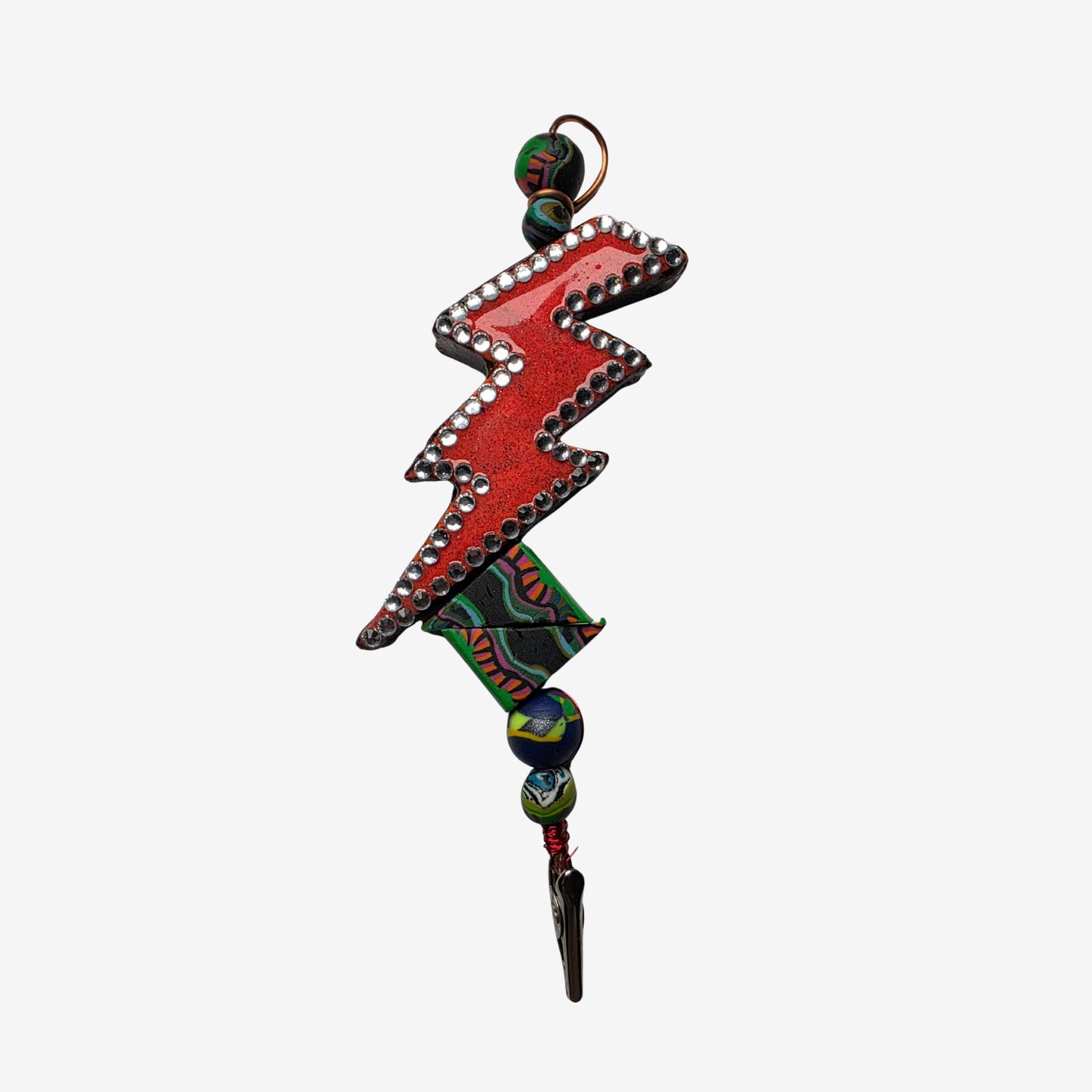 Colorful polymer clay card clips with bold patterns, spikes, roses, feathers, and sculpted designs — wearable mini artworks that fuse art, originality, and utility