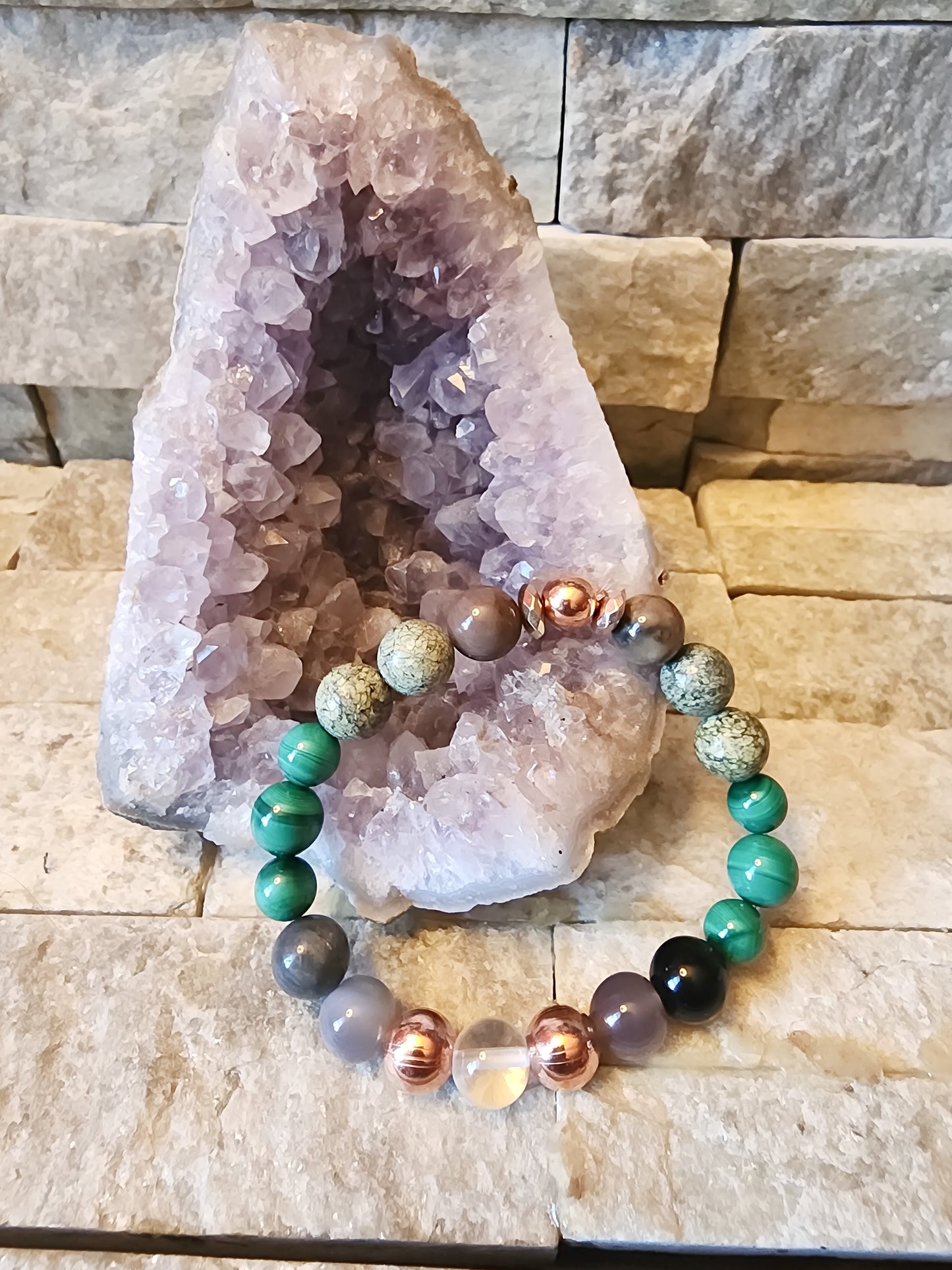 Ashes & Alchemy handmade crystal bracelet featuring malachite, labradorite, moonstone, serpentine jade, petrified wood, and clear quartz with raw copper for transformation and rebirth