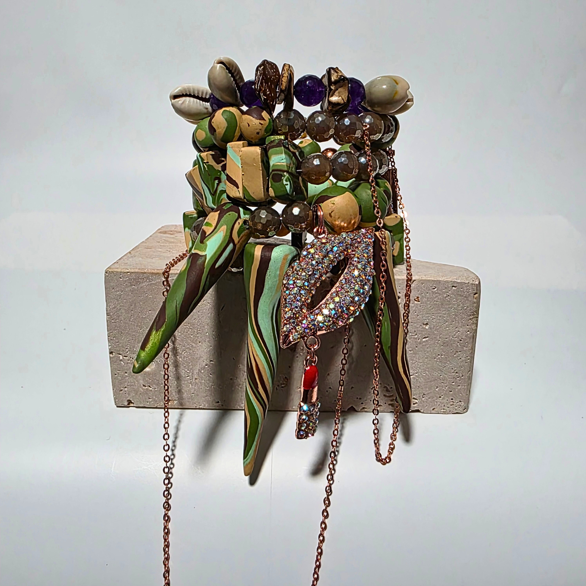 Camo-patterned artisan bracelet featuring purple jade, agate crystals, cowrie shells, and copper chain.