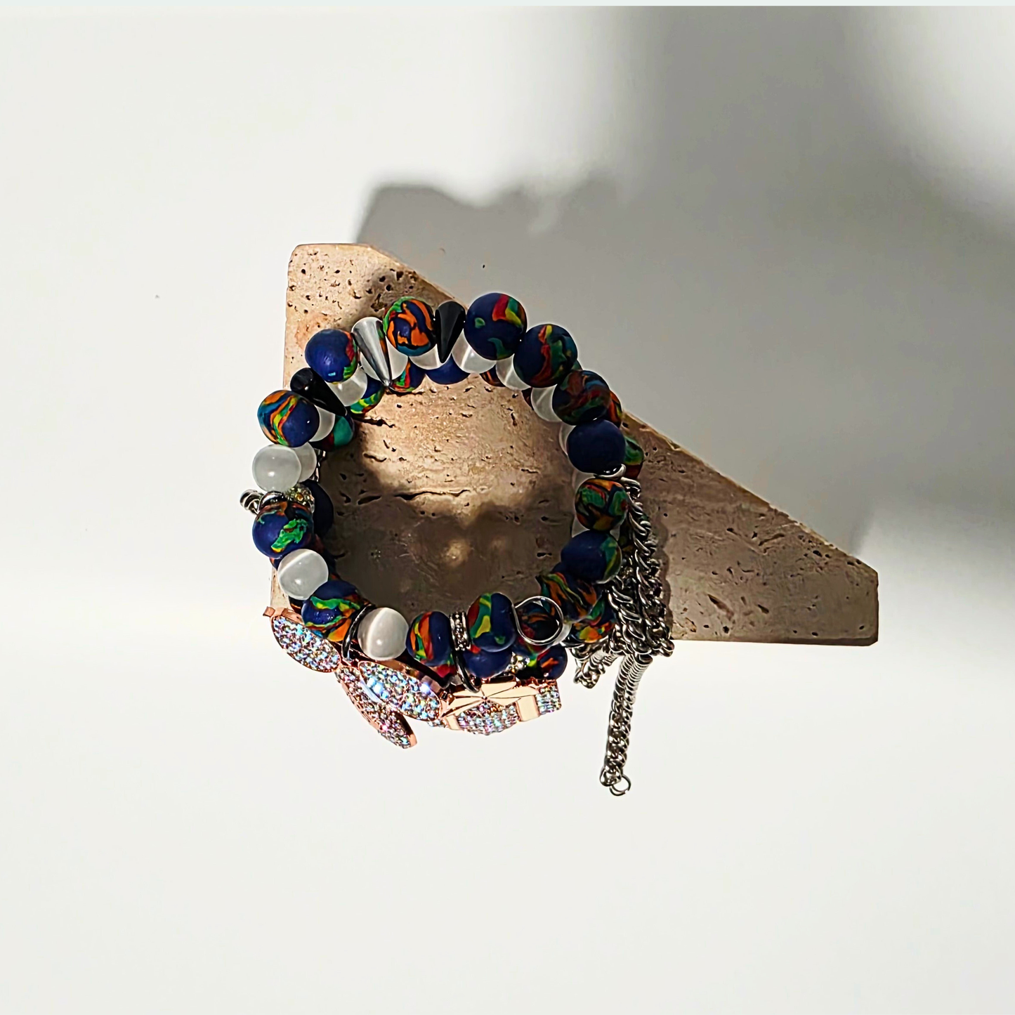 Ivory Riot statement bracelet — 3 shimmering charms, sterling chains, handmade clay beads, and polished white cat’s eye crystals.