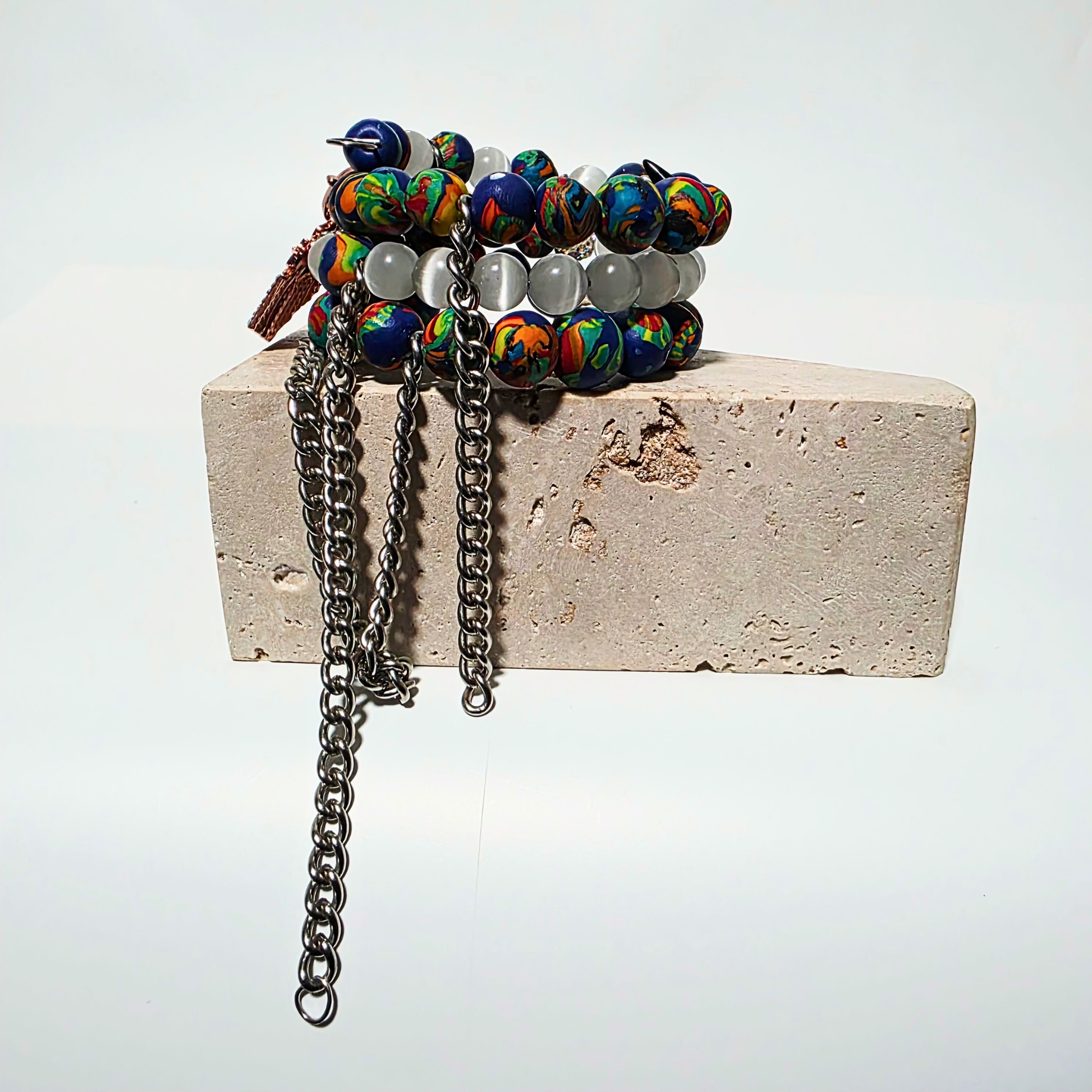 JvOR Ivory Riot — artisanal multi-loop bracelet with white cat’s eye beads, clay beads, silver chains, and sparkling rhinestone charms.