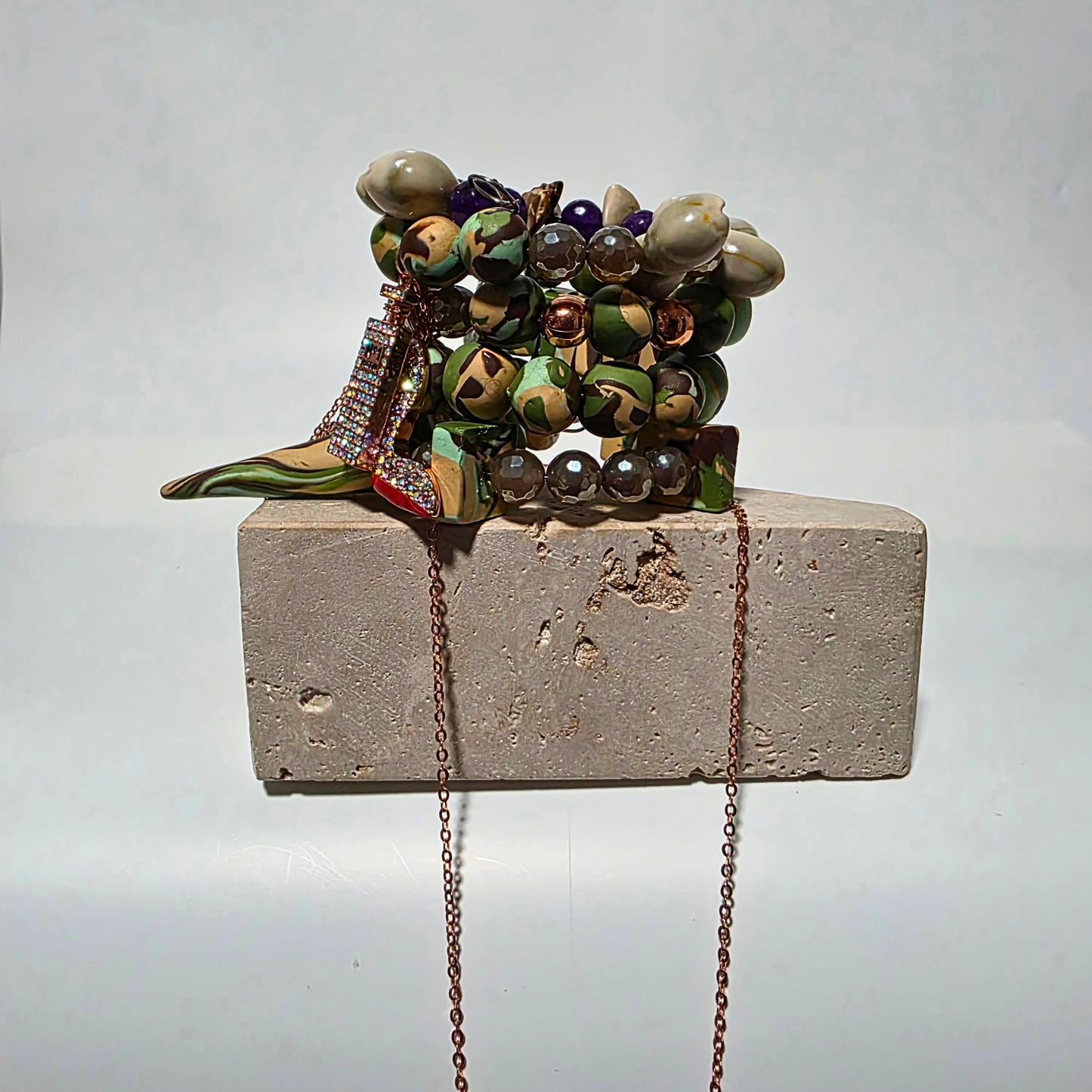 Camo-patterned artisan bracelet featuring purple jade, agate crystals, cowrie shells, and copper chain. Back view