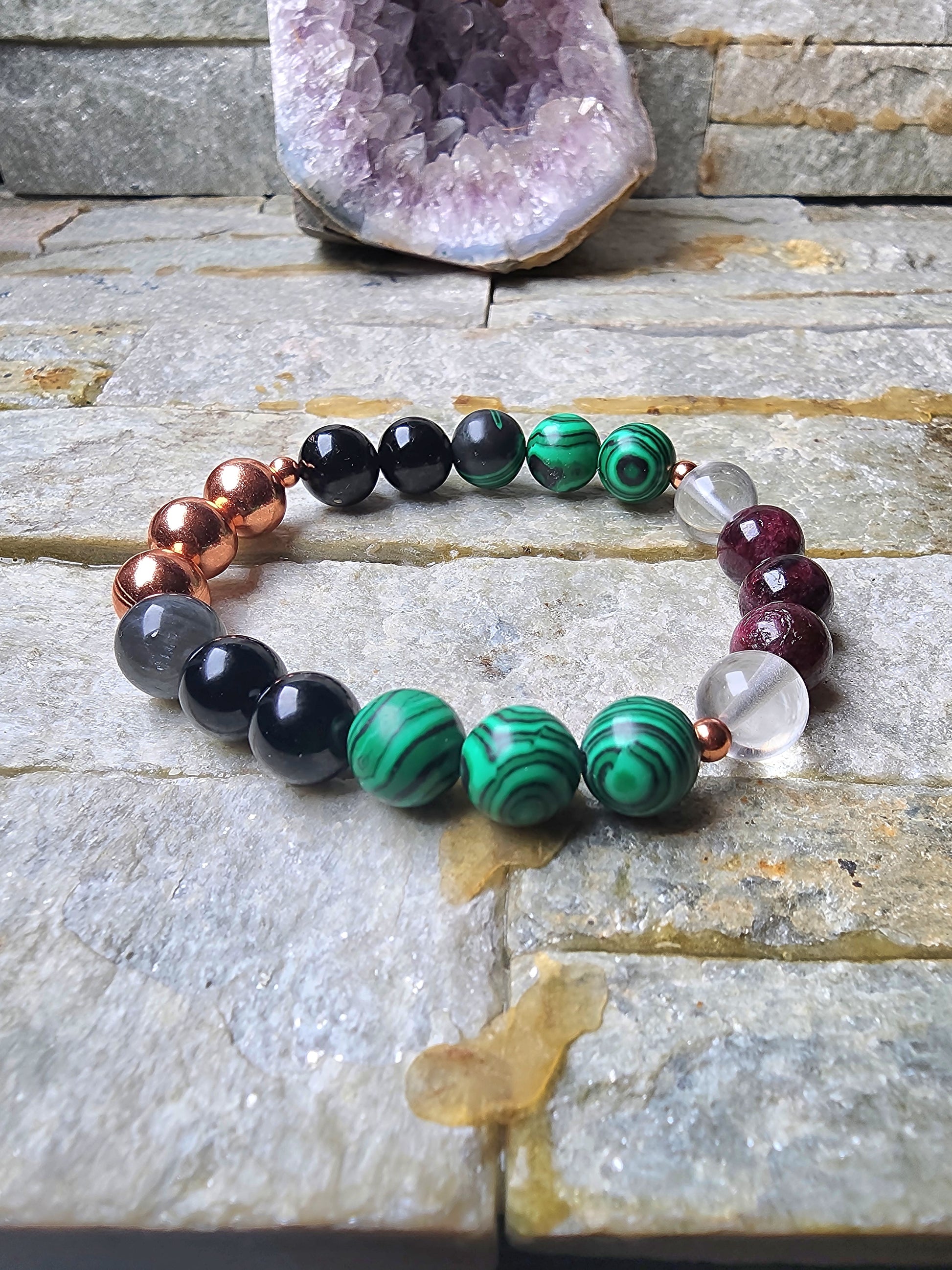 Ember Shield bracelet made with garnet, tourmaline, malachite, labradorite, and clear quartz worn on left wrist for grounding, protection, emotional strength, and energy defense