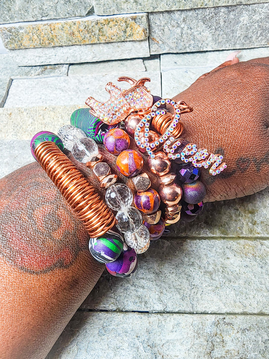 EROS BRACELET STACK FEATURING RICH TONES, METALLICS, & QUEEN CHARM - A DIVINE FUSION OF LOVE, ART, & EMPOWERMENT.