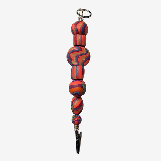 Colorful polymer clay card clips with bold patterns, spikes, roses, feathers, and sculpted designs — wearable mini artworks that fuse art, originality, and utility