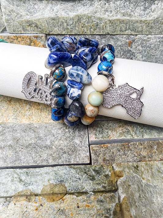 KISHA THE REMIX BRACELET STACK IN COOL BLUE TONES WITH STATEMENT CHARMS - HANDCRAFTED FOR BOLD EXPRESSION AND GROUNDING.
