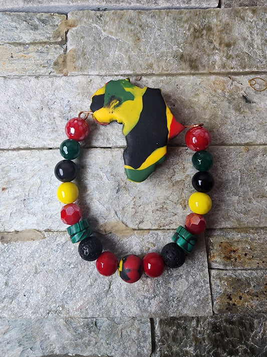 Handmade bracelet with polymer clay beads in Pan-African colors, spike shapes, jade gemstones, and a bold Africa-shaped focal bead — honoring heritage and spiritual power.