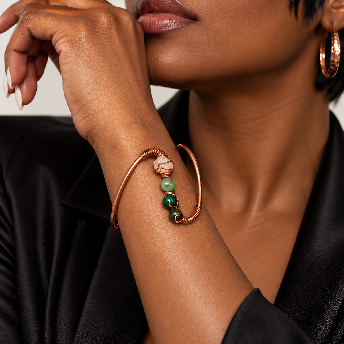 Black woman wearing the JvOR Aje handmade copper prosperity cuff on her wrist